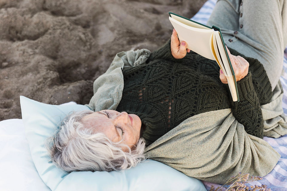 Woman resting on a pillow while reading a book