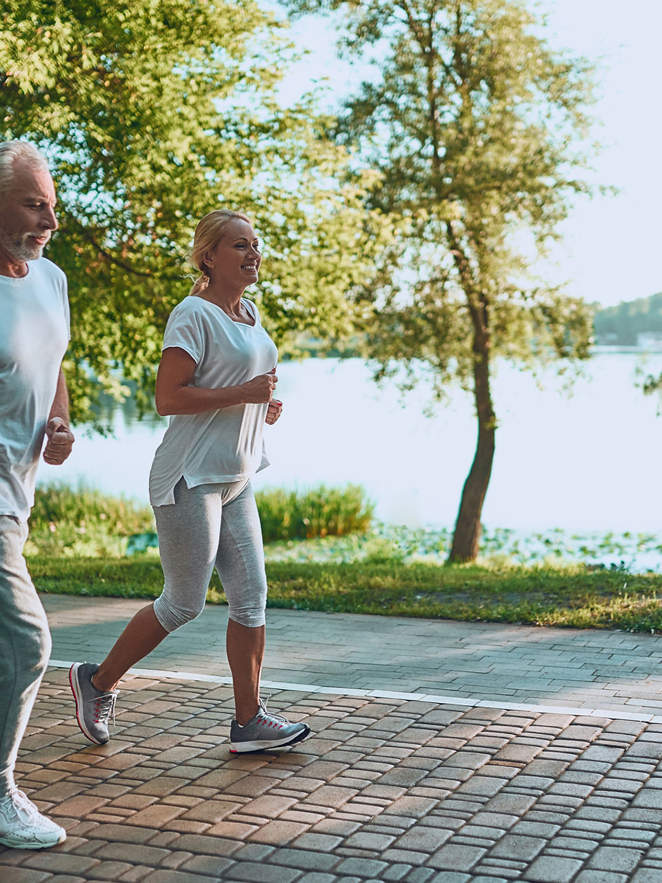 Older woman jogging along a waterfront path