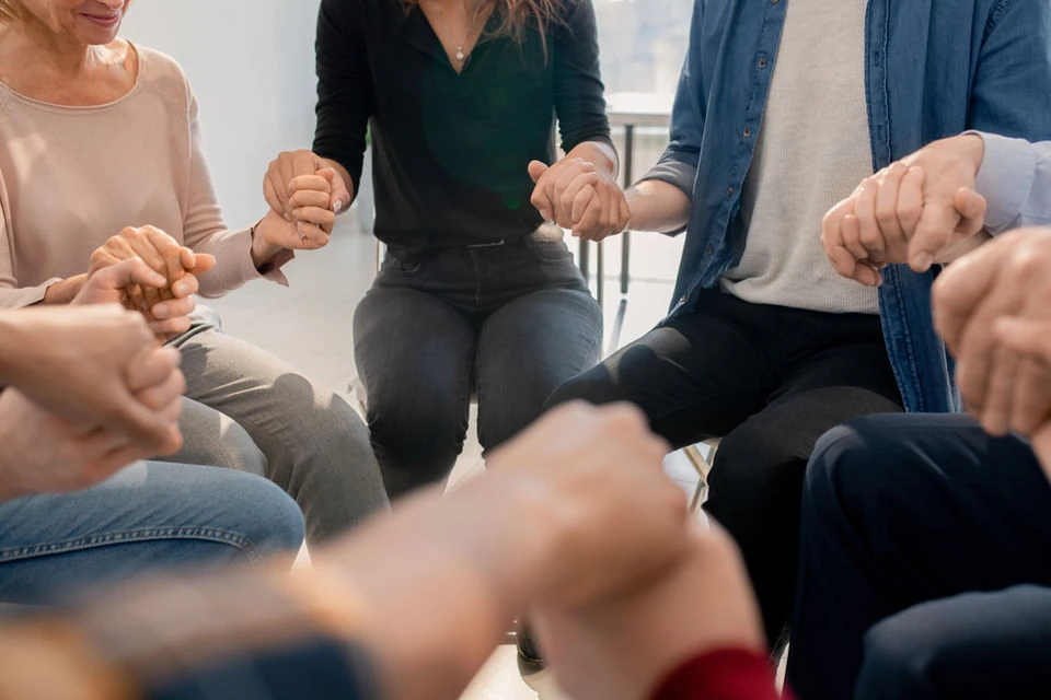 Support group holding hands in a circle