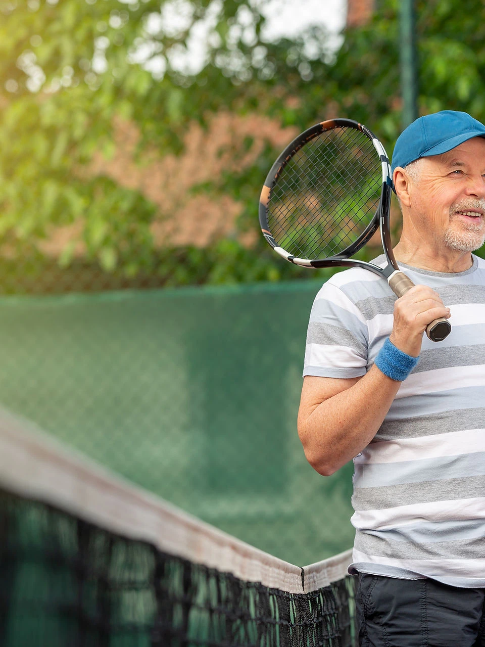 Older man playing tennis outdoors