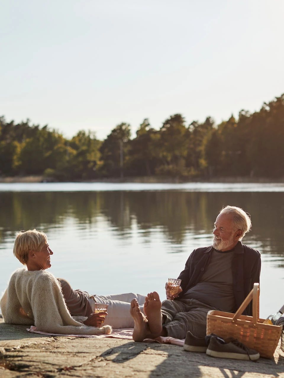Older couple enjoying a picnic beside a lake
